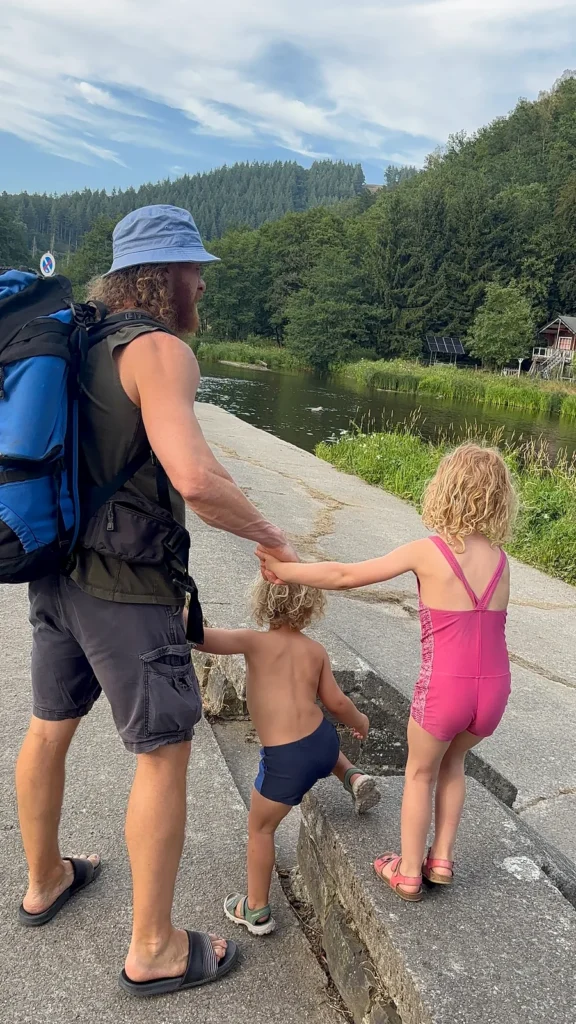 Vader wandelt met twee kleine kinderen naar de Ourthe bij Maboge Plage